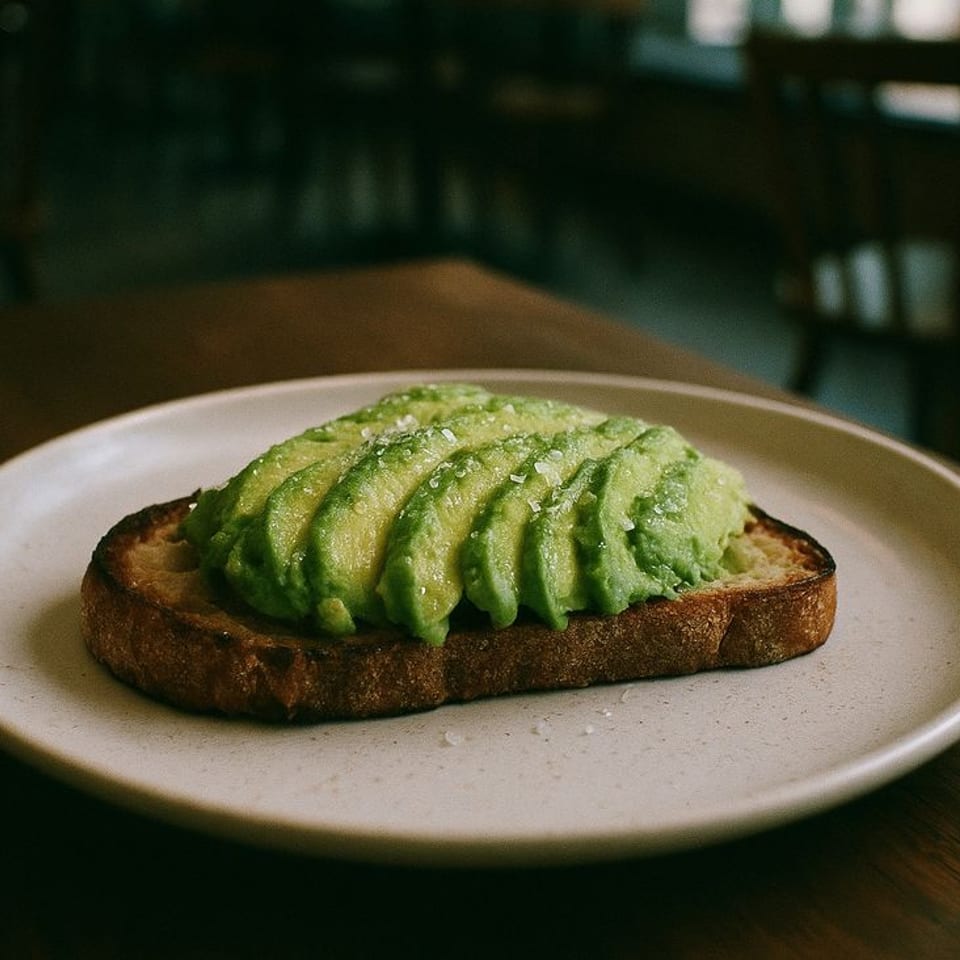 Avocado toast with sliced avocado and sea salt on a white plate at Annex Coffee.
